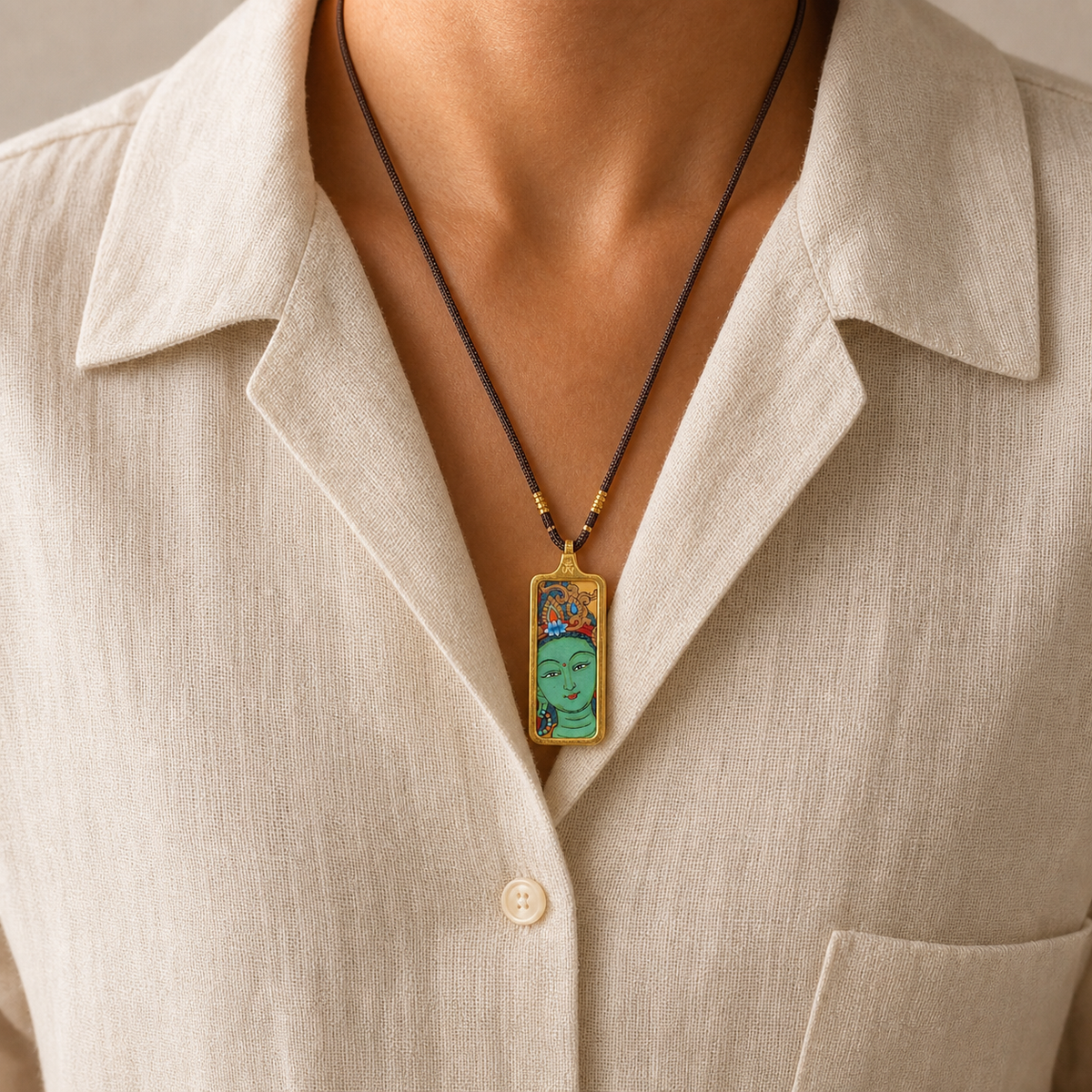 Eastern Luck Green Tara mini Tibetan thangka pendant — fine cord worn on ivory linen shirt — image 6 of 10
